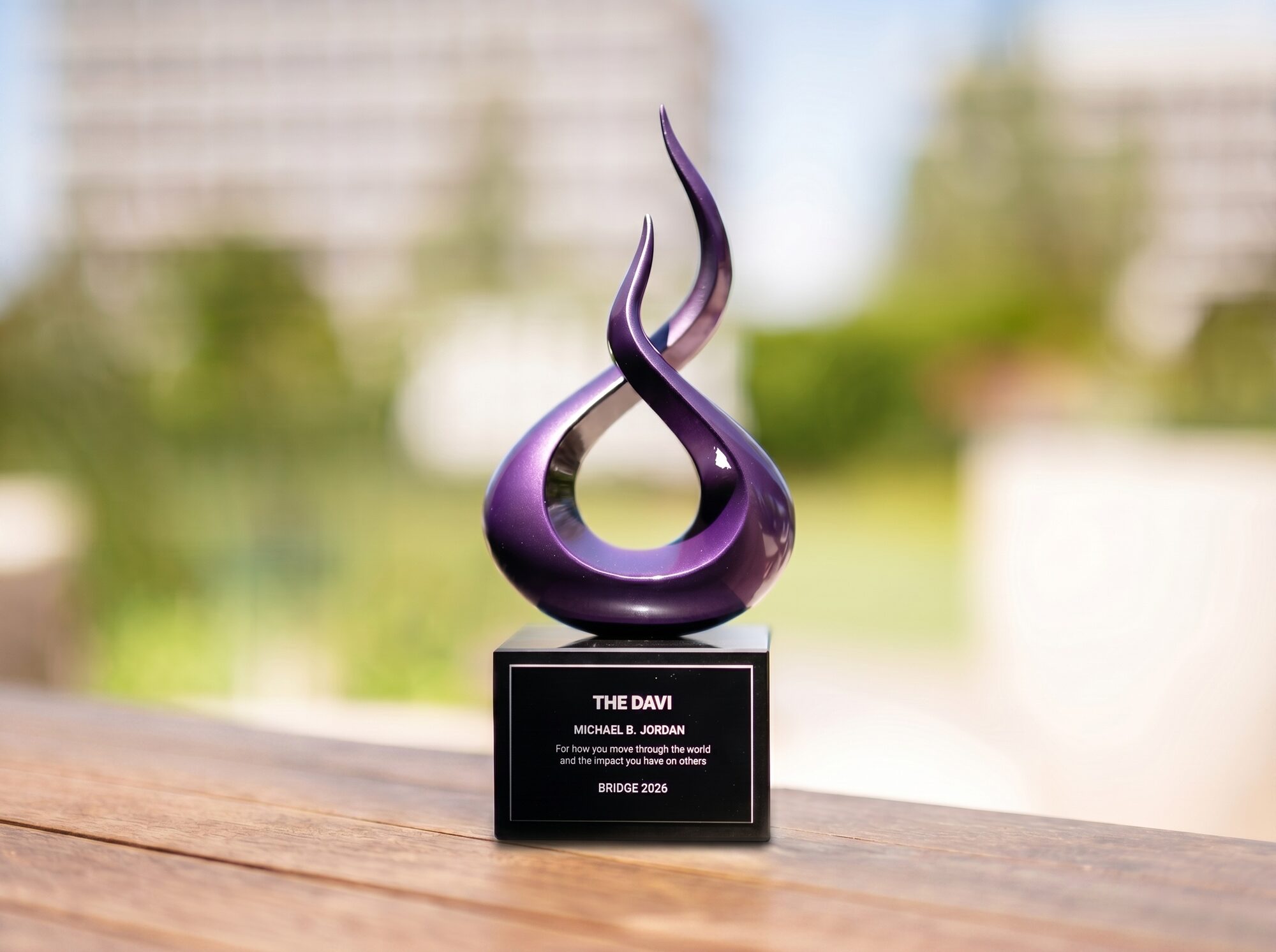 The Davi award — a sculptural purple glass form on a black inscribed base.